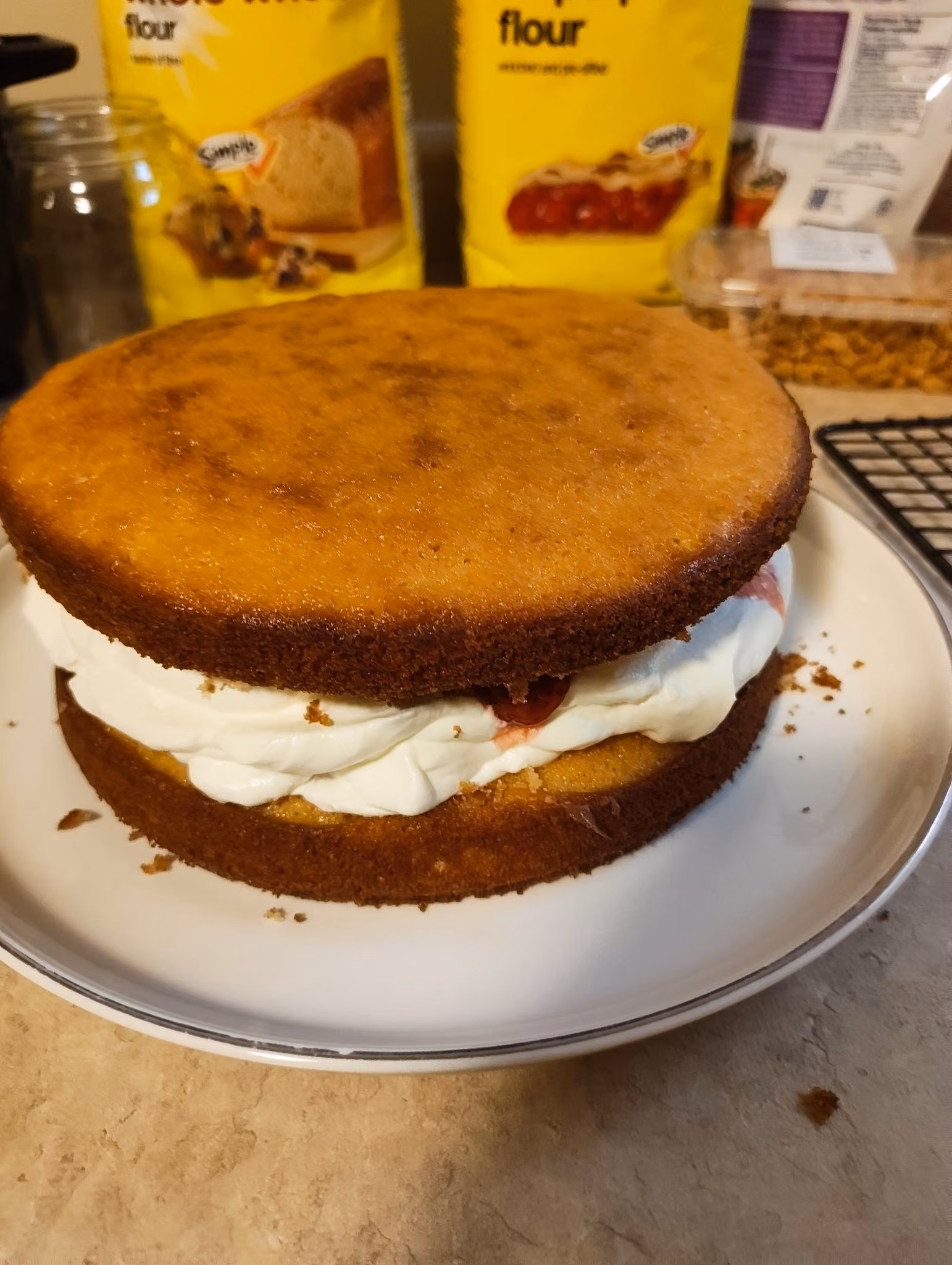 Two tiered cake with strawberries and cream in the center